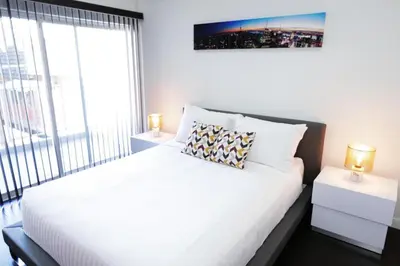 a bedroom with a large white bed with two lamps at Downtown Cosmopolitan Residences in Los Angeles