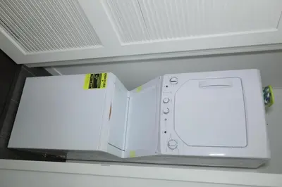 a white microwave oven sitting on top of a shelf at Downtown Cosmopolitan Residences in Los Angeles
