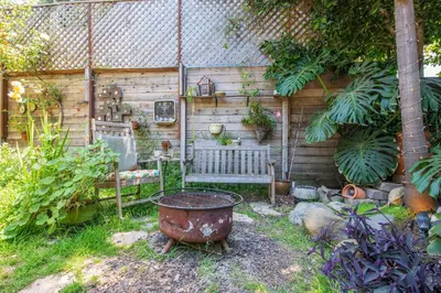 a garden with a rusty pot and a bench at Oasis Hollywood in Los Angeles
