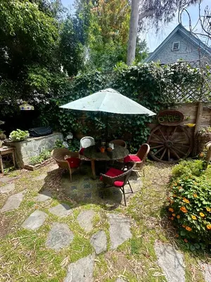 a table and chairs with an umbrella in a yard at Oasis Hollywood in Los Angeles
