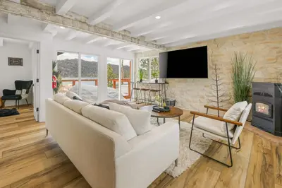 a living room with a white couch and a fireplace at Luxe Lakefront with Hot Tub, Fire Pit, Game Room, Boat Dock in Big Bear Lake