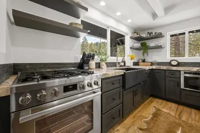 a kitchen with stainless steel appliances and gray cabinets at Luxe Lakefront with Hot Tub, Fire Pit, Game Room, Boat Dock in Big Bear Lake