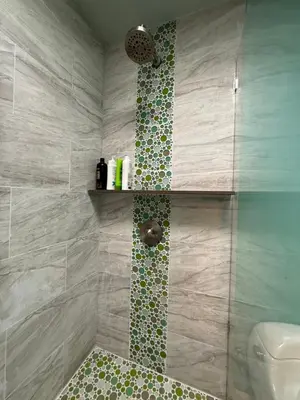 a bathroom with a shower with a tiled wall at Pasadena Old Town Cottage in Pasadena