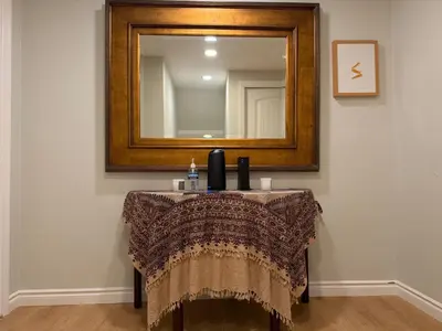 a table in a room with a mirror and a dressing table at Pasadena Old Town Cottage in Pasadena