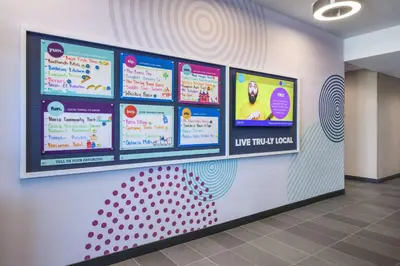 a wall with several signs on a wall at Tru by Hilton Norco Eastvale in Norco