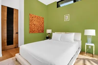 a bedroom with a white bed and a green wall at The Bella Villa Venice Beach - luxury interior design - spa and terrace in Los Angeles