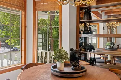 a dining room with a table and two windows at Big Bear Lake Sleep 16 in Big Bear Lake
