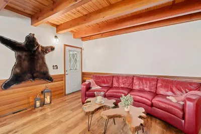 a living room with a red couch and a bear statue at Big Bear Lake Sleep 16 in Big Bear Lake