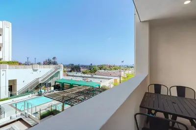 a balcony with a table and a view of a building at Blueground Mid-Wilshire pool near The Grove LAX-1223 in Los Angeles