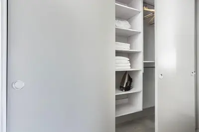 a closet with white shelves and a door at Blueground Mid-Wilshire pool near The Grove LAX-1223 in Los Angeles