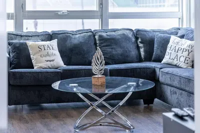 a living room with a blue couch with a glass table at 2 Bed 2 Bath X street LA Live, Convention Center, Microsoft Theater in Los Angeles