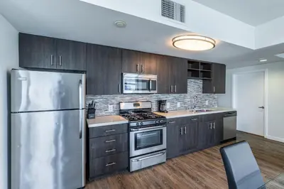 a kitchen with wooden cabinets and a stainless steel refrigerator at 2 Bed 2 Bath X street LA Live, Convention Center, Microsoft Theater in Los Angeles