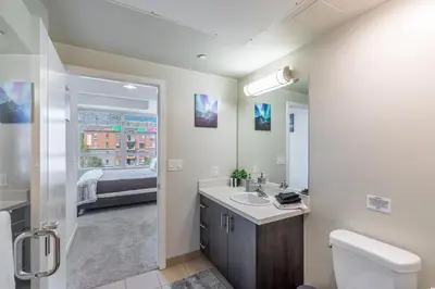 a bathroom with a sink and a toilet and a bed at 2 Bed 2 Bath X street LA Live, Convention Center, Microsoft Theater in Los Angeles