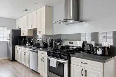 a kitchen with white cabinets and a stove top oven at Luxury Oasis in Culver City! Free parking and Jacuzzi in Los Angeles