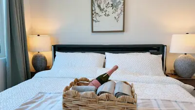 a basket with a bottle of wine on a bed at Cozy 2B1B Apt Prime Location Newly Remodeled in Alhambra