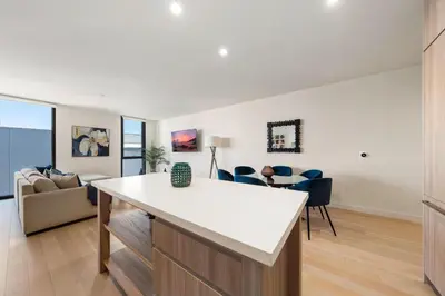 a kitchen and living room with a table and chairs at The Sapphire Nest - Spectacular Rooftop Amenities Ocean views 2BR in Los Angeles