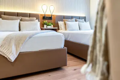two beds in a hotel room with white pillows at LYFE INN & SUITES by AGA - Beverly Hills in Los Angeles