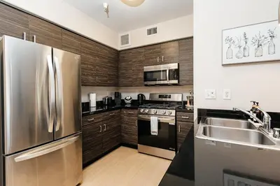 a kitchen with stainless steel appliances and wooden cabinets at Luxury One Bedroom minutes from The Grove in Los Angeles