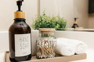 a bottle of hand sanitizer next to a stack of towels at Luxury One Bedroom minutes from The Grove in Los Angeles