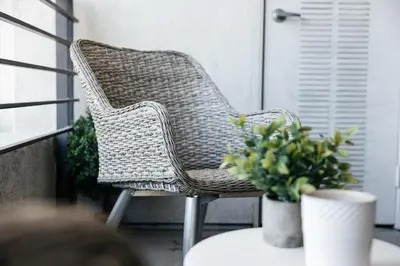 a wicker chair sitting on a porch with a table at Luxury One Bedroom minutes from The Grove in Los Angeles