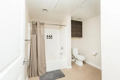a bathroom with a toilet and a shower with a shower curtain at Luxury One Bedroom minutes from The Grove in Los Angeles