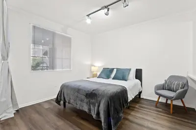a white bedroom with a bed and a chair at 4bd Townhouse - Special Limited Time Offer near Venice Beach! in Los Angeles