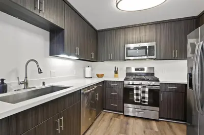 a kitchen with wooden cabinets and stainless steel appliances at 4bd Townhouse - Special Limited Time Offer near Venice Beach! in Los Angeles