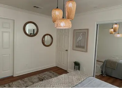 a bedroom with a bed and two chandeliers and a mirror at Cozy and Spacious Duplex in Los Angeles