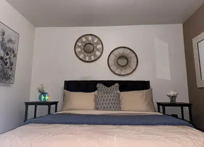 a bedroom with a bed with two mirrors on the wall at Cozy and Spacious Duplex in Los Angeles