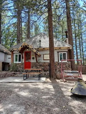 a house with a red door in the woods at Big Bear Lake - Tulip Lane Cabin #25 in Big Bear Lake
