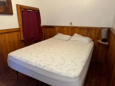 a small bed in a room with a red towel at Big Bear Lake - Tulip Lane Cabin #25 in Big Bear Lake