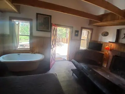 a bathroom with a tub and a window and a door at Big Bear Lake - Tulip Lane Cabin #26 in Big Bear Lake
