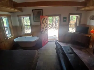 a bathroom with a tub and a window and a door at Big Bear Lake - Tulip Lane Cabin #26 in Big Bear Lake