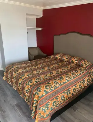 a bed in a room with a red wall at Hi Rise Motel in Lynwood