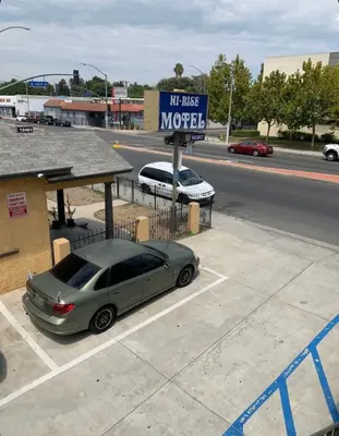 a car parked in a parking lot next to a sign at Hi Rise Motel in Lynwood