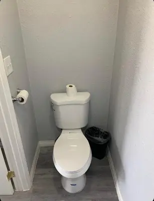 a bathroom with a toilet with a roll of toilet paper at Hi Rise Motel in Lynwood