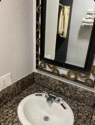 a bathroom with a white sink and a mirror at Hi Rise Motel in Lynwood