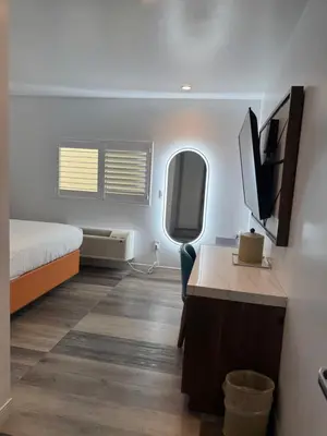 a room with a bed and a desk with a tv at Hotel Rudra - Hollywood in Los Angeles