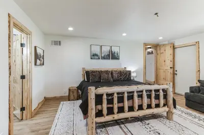 a bedroom with a wooden bed and a couch at Timeless Traditions Arrowhead home in Lake Arrowhead
