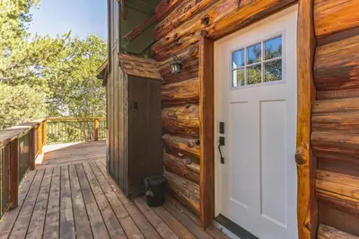 a door to a cabin with a deck at Timeless Traditions Arrowhead home in Lake Arrowhead