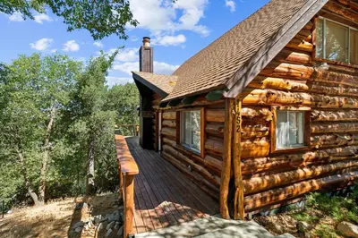 a log cabin with a wooden deck at Timeless Traditions Arrowhead home in Lake Arrowhead
