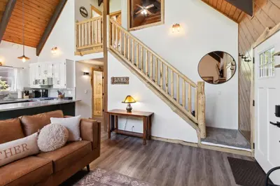 a living room with a couch and a staircase at Timeless Traditions Arrowhead home in Lake Arrowhead