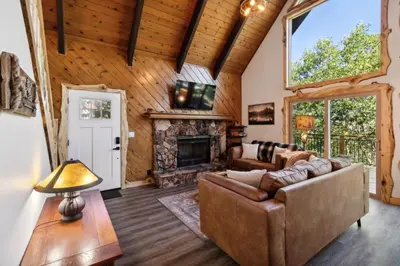 a living room with a couch and a fireplace at Timeless Traditions Arrowhead home in Lake Arrowhead