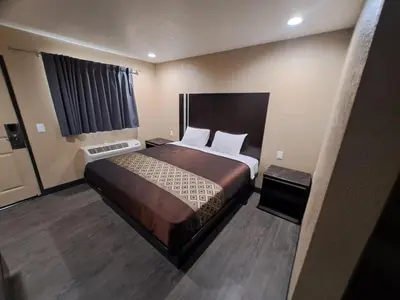 a bedroom with a large bed in a room at American Inn i10 Rialto and Colton in Rialto