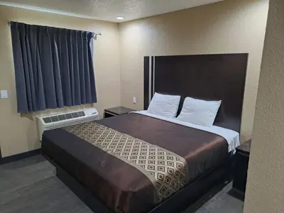 a bedroom with a large bed in a hotel room at American Inn i10 Rialto and Colton in Rialto