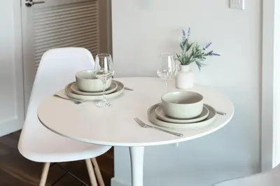 a white table with two glasses and plates on it at Beautiful 1BR Apt in Hollywood w Pool and Parking in Los Angeles