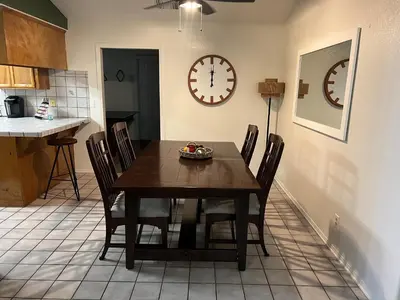 a dining room with a table and a clock on the wall at Cheerful 3BR 2BA Sauna Spa Pool Table PPong BBQ More in Lancaster