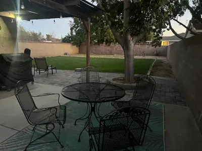 a patio with a table and chairs and a tree at Cheerful 3BR 2BA Sauna Spa Pool Table PPong BBQ More in Lancaster