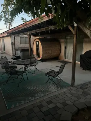 a patio with a table and chairs in front of a building at Cheerful 3BR 2BA Sauna Spa Pool Table PPong BBQ More in Lancaster