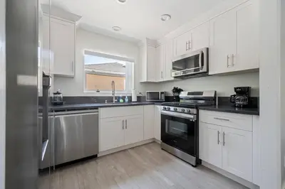 a kitchen with white cabinets and stainless steel appliances at Serene Home in Central Burbank in Burbank